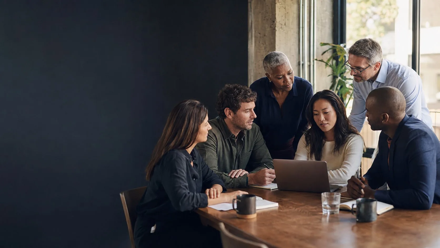 A team of leaders and colleagues collaborating together around a table